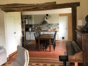 a dining room with a wooden table and chairs at Le gîte aux ânes du Sancerrois in Menetou-Râtel