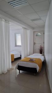 a bedroom with two beds with white walls at Lägenhet/Studio Grand in Jajce