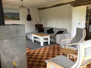 a living room with a couch and a table at Le gîte aux ânes du Sancerrois in Menetou-Râtel