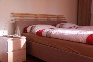 a bedroom with a bed with a wooden headboard and a night stand at Guest House Krpole in Brno