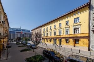 a street with cars parked in front of buildings at Готель Кайзер Економ in Lviv