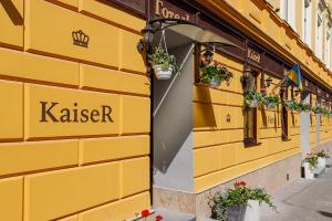 a yellow building with potted plants on the side of it at Готель Кайзер Економ in Lviv +16 photos