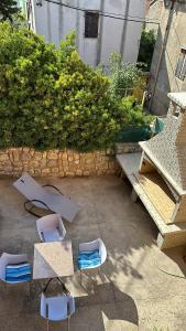 a patio with chairs and tables and a bench at Apartments Cunski in Čunski