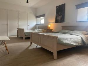 a bedroom with two beds and a couch and a table at Vakantiehuis Buitengewoon in Beers