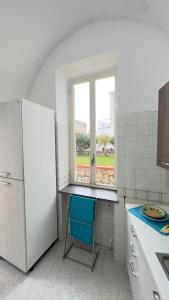 een keuken met een witte koelkast en een blauwe stoel bij Mira Mila in Massa Lubrense
