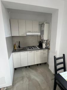 a small kitchen with white cabinets and a sink at Everest 33 Ap 4 in Bucharest