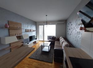 a living room with a couch and a table at SUNRAY Apartman Požarevac in Požarevac