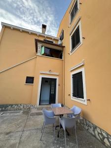 a table and chairs in front of a building at Apartments Cunski in Čunski