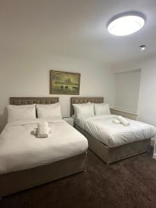 2 Betten in einem Hotelzimmer mit ausgestopftem Tier drauf in der Unterkunft The Chapter Hotels - Mayfair Residences in London
