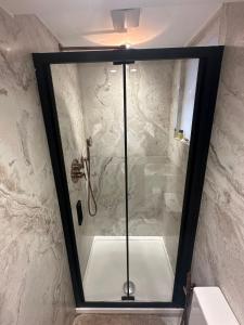 a shower with a glass door in a bathroom at The Chapter Hotels - Mayfair Residences in London