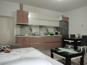 uma cozinha com uma cama e uma mesa num quarto em ERTEO Guest House em Pogradec