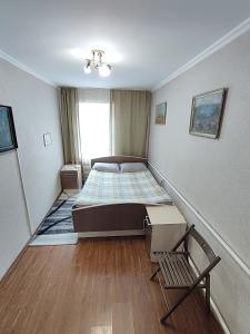 卡拉科爾的住宿－Hostel Nice，一间卧室配有一张床和一把椅子