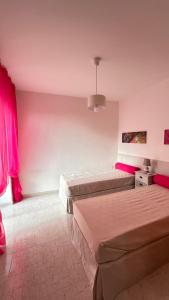 twee bedden in een kamer met roze muren bij Mira Mila in Massa Lubrense