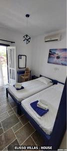 a bedroom with two beds and a tv at Elisso Villas in Platis Gialos