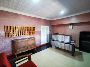 Résidence touristique du chêne vert في إفران: غرفة مع قبو للنبيذ مع كرسي وتلفزيون