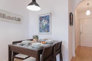 a dining room with a table with chairs and a painting at AT Tino Casal in Almería +4 photos