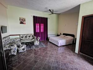 een slaapkamer met een bed, een bank en een tafel bij Résidence touristique du chêne vert in Ifrane