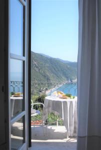 a balcony with a table with a view of the ocean at My Place Your Place in Corniglia