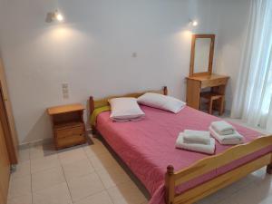 a bedroom with a bed with two towels on it at Elena Rooms in Agios Nikitas