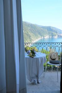 a table on a balcony with a view of the ocean at My Place Your Place in Corniglia