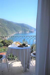 a table on a balcony with a view of the ocean at My Place Your Place in Corniglia