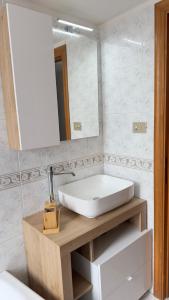 een badkamer met een witte wastafel en een spiegel bij Mira Mila in Massa Lubrense
