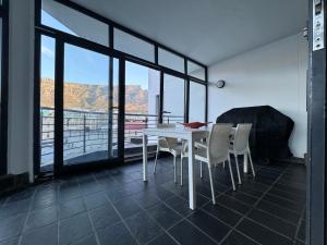 una mesa blanca y sillas en una habitación con vistas en @Liam Flatrock, en Ciudad del Cabo