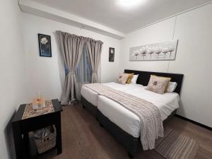 Un dormitorio con una cama grande y una mesa. en @Liam Flatrock, en Ciudad del Cabo