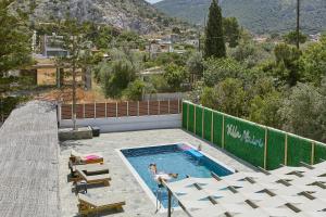 una persona nadando en una piscina con montañas en el fondo en Villa Mairi, en Salamina