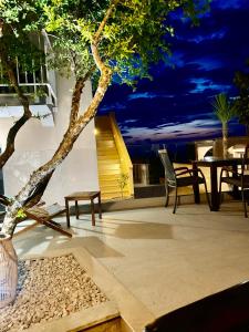 eine Terrasse mit einem Baum, einem Tisch und Stühlen in der Unterkunft Marojica Apartments 2 in Cavtat