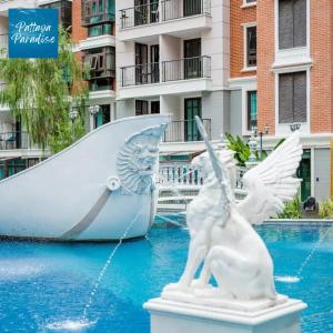 a statue of two white pigeons and a boat at Espana Resort Jomtien Beach Pattaya in Jomtien Beach