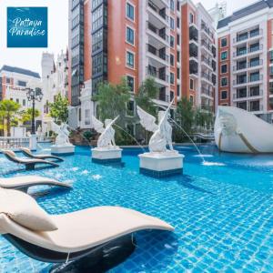 a hotel swimming pool with statues in the water at Espana Resort Jomtien Beach Pattaya in Jomtien Beach