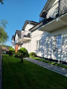 GRAND VILLA USTKA- Marmonoli في أوستكا: منزل مع حديقة خضراء بجوار مبنى