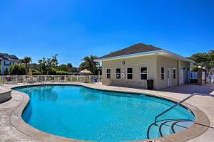 a swimming pool in front of a house at Golf Getaway with Pool Access in Myrtle Beach! in Myrtle Beach