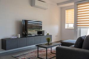 a living room with a couch and a tv at LA88 Cityway Apartment 5 in Il-Gżira