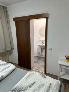 una camera con letto e un bagno con lavandino di Hotel Gambrinus a Pachten