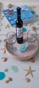 uma garrafa de vinho e dois copos numa mesa em Orizodas em Lipsoi