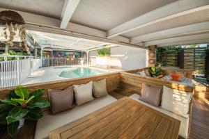 una terraza al aire libre con piscina profunda, mesa y bancos en Pousada dos Sonhos en Florianópolis