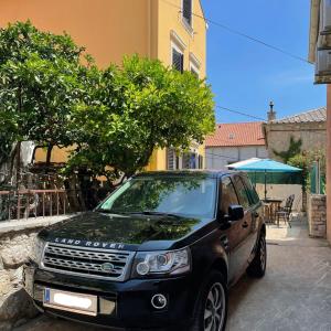 a car parked on a street next to a building at Apartments Cunski in Čunski +39 photos