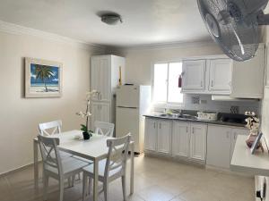 cocina con mesa, sillas y nevera en Karimar Beach Condo Hotel, en Punta Cana