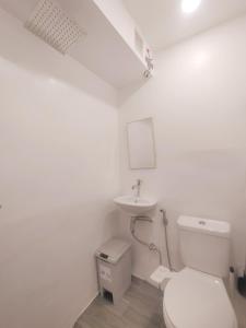 biała łazienka z toaletą i umywalką w obiekcie VG Pension & Residences w mieście Adlawon