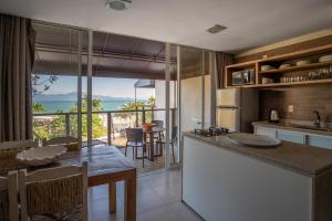 eine Küche und ein Esszimmer mit Meerblick in der Unterkunft Pousada dos Sonhos in Florianópolis