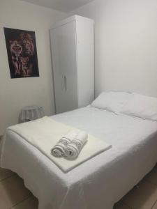 a white bed with two towels on it at Apartamento em Condomínio Marinas Clube in São Pedro da Aldeia +38 photos