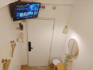 Pokój z telewizorem na ścianie obok drzwi w obiekcie VG Pension & Residences w mieście Adlawon