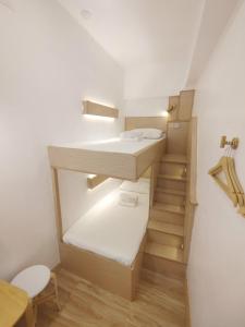 een kleine kamer met een stapelbed en een trap bij VG Pension & Residences in Adlawon