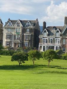 a large mansion with trees in a field of grass at Brundholme in Keswick