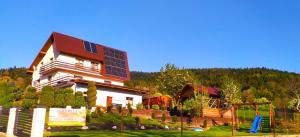una casa grande con paneles solares encima en Agrorelax - Kasina Wielka, en Kasina Wielka
