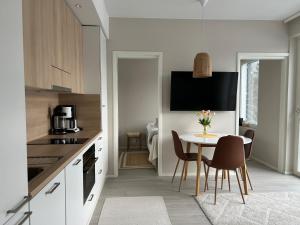 a kitchen with a table and chairs and a kitchen with white cabinets at Skyview apartment Kalajoki Hiekkasärkät in Kalajoki +5 photos