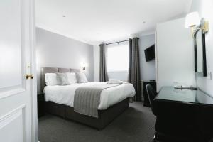 Un dormitorio con una cama grande y una ventana en New Inn Hotel, en Ellon