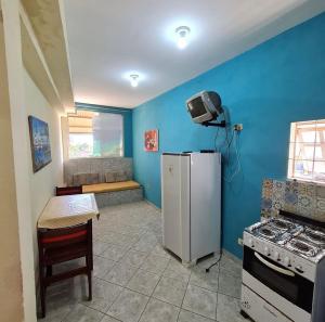 a kitchen with a white refrigerator and a stove at Pousada pirata in Recife